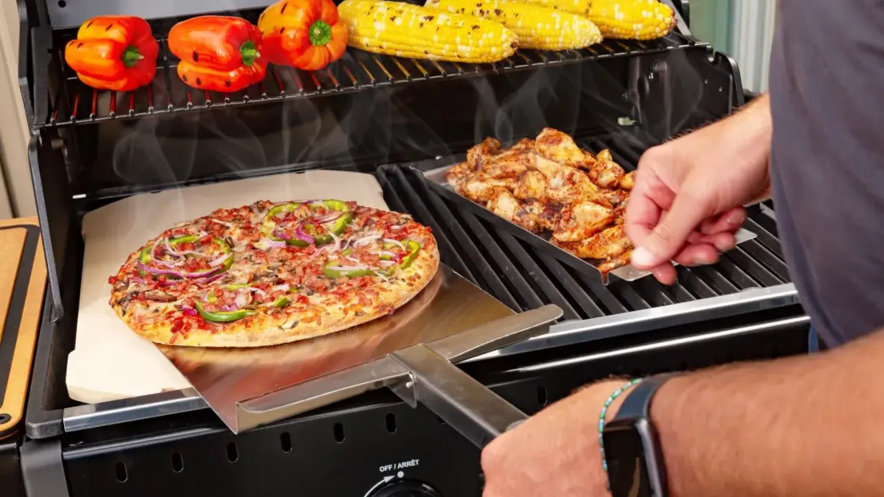 Pyszna pizza z grilla węglowego, obok kurczak i kukurydza.