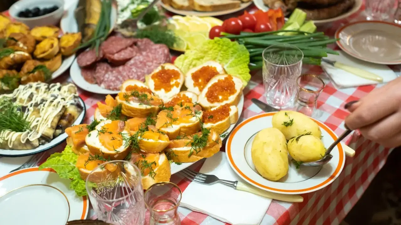 Obficie zastawiony stół z wędlinami, rybami, kawior i ziemniakami to raj dla miłośników turystyki kulinarnej.