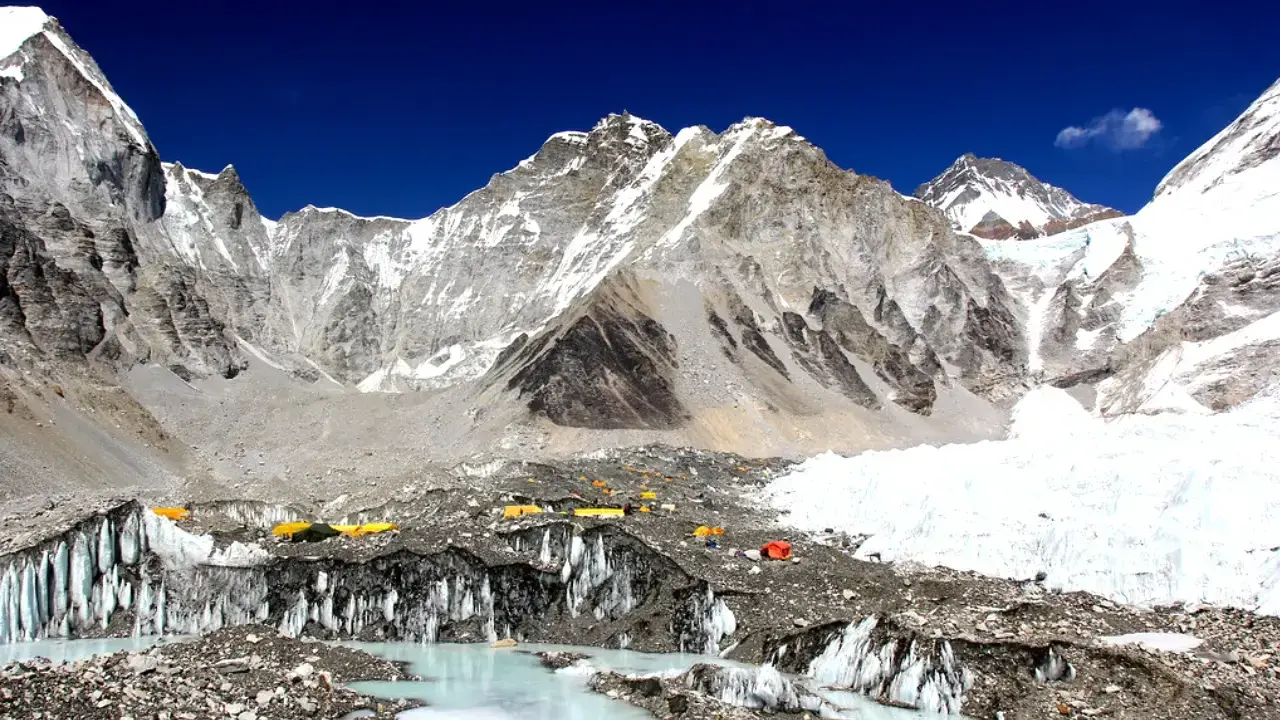 Obóz pod Everestem, z namiotami i lodowcem. Planując wyprawę, warto sprawdzić everest base camp koszty.