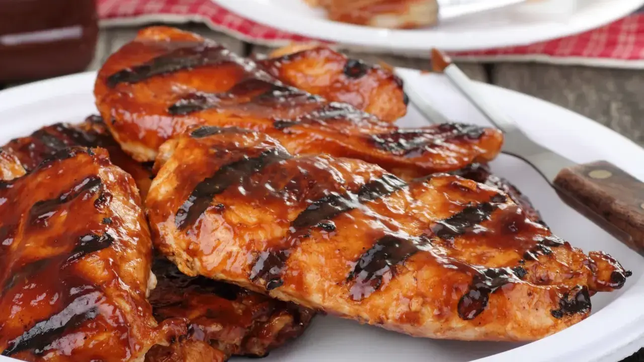 Soczysty kurczak z grilla elektrycznego, polany sosem BBQ. Idealny na letnie popołudnie, a jak długo grillować kurczaka na grillu elektrycznym? To pytanie, na które odpowiedź znajdziesz w przepisach!