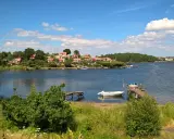 Idealny weekend w Szwecji: malownicza zatoka, czerwone domki na wzgórzu, drewniane pomosty i łodzie.