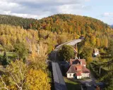 Jesienna panorama Gór Sowich z widokiem na malowniczy wiadukt kolejowy i domy. Atrakcje regionu w pełnej krasie.