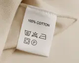 Metka z napisem "100% COTTON" informuje, że materiał to bawełna. Pielęgnacja: pranie w 40°C, nie wybielać, prasować w średniej temperaturze, można czyścić chemicznie.