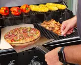 Pyszna pizza z grilla węglowego, obok kurczak i kukurydza.