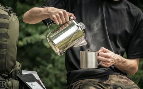 Mężczyzna nalewa kawę do kubka z metalowego czajniczka. Obok leży plecak i paczki kawy. Idealny **aeropress przepis** na kempingu.