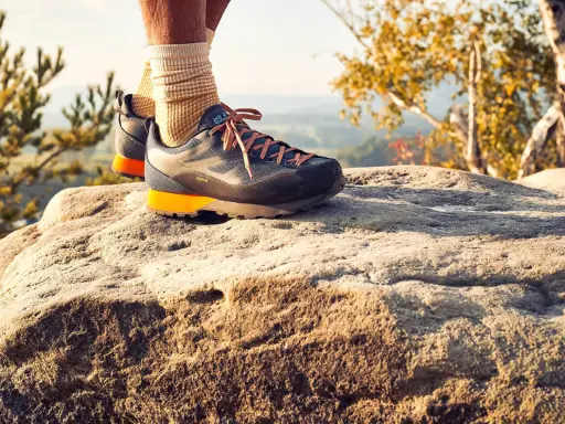 Idealne buty w Bieszczady? Te trekkingowe z pomarańczowymi akcentami zapewnią komfort na kamienistym szlaku.