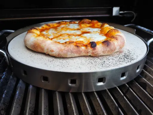 Pyszna pizza z grilla, z rumianym brzegiem i ciągnącym się serem, właśnie trafia na ruszt.