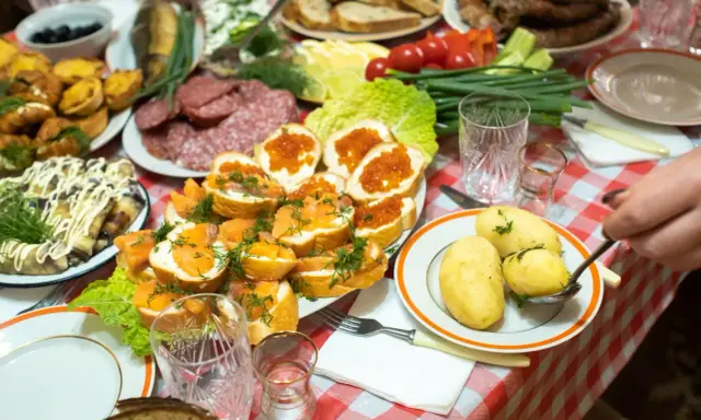 Obficie zastawiony stół z wędlinami, rybami, kawior i ziemniakami to raj dla miłośników turystyki kulinarnej.