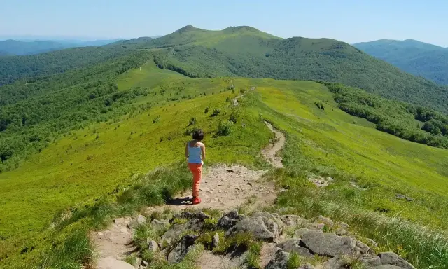 Dziewczynka na szlaku w zielonych górach. Gdzie w Tatry? Tu jest pięknie, zielono i słonecznie.