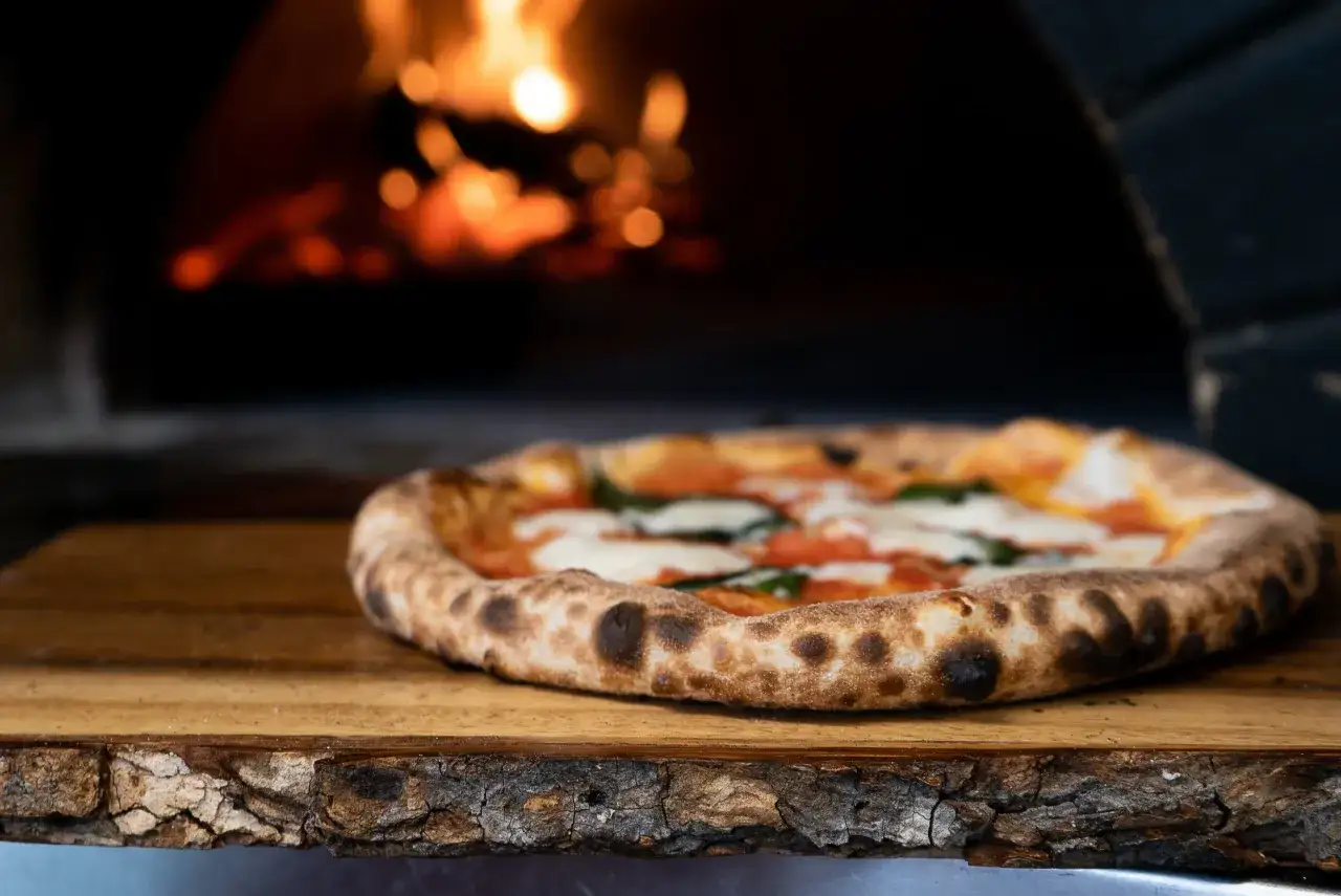 Idealna pizza na kamieniu, wypiekana w ogniu. Zobacz, jak piec pizze na kamieniu, by uzyskać chrupiące ciasto i idealne składniki.