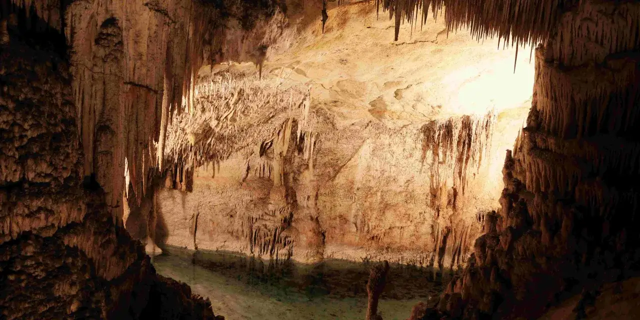 Niesamowite jaskinie do zwiedzania w Polsce. Stalaktyty i stalagmity tworzą bajkowy krajobraz nad krystalicznie czystą wodą.
