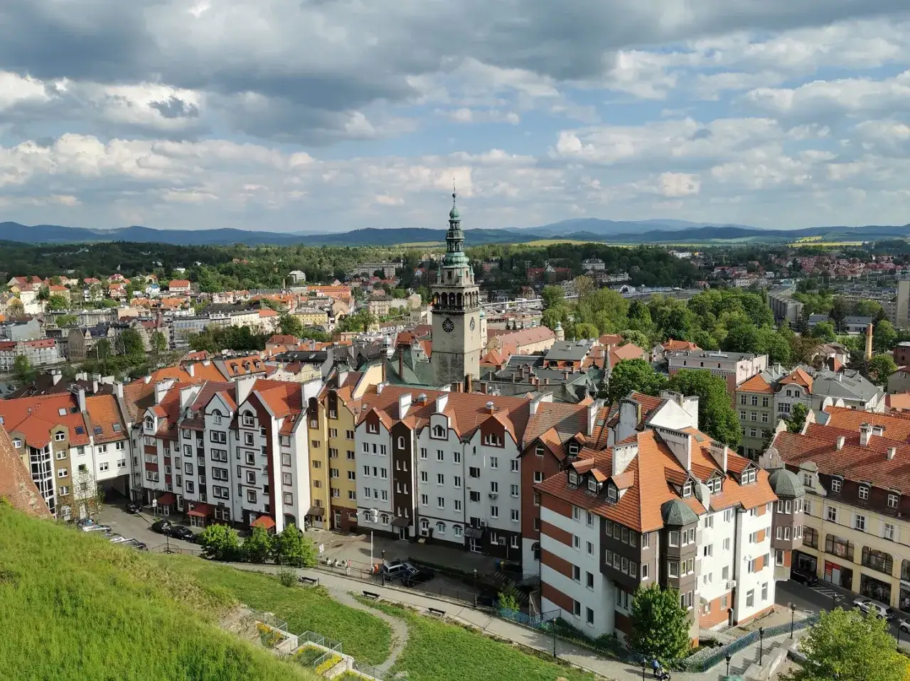 Widok na urokliwe miasteczko w okolicach Wrocławia z charakterystyczną wieżą zegarową i kolorowymi kamienicami.