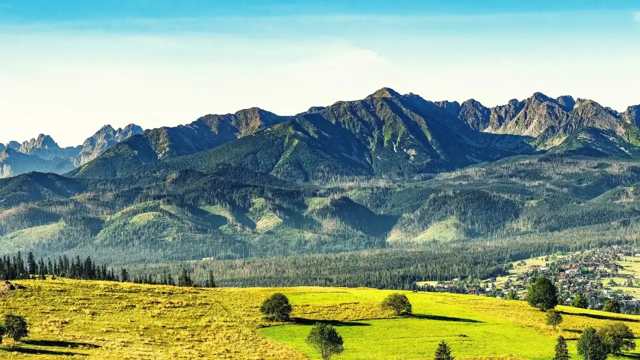 Zielone wzgórza i lasy prowadzą wzrok ku majestatycznym szczytom. Gdzie w Tatry? Tu, gdzie natura zachwyca.