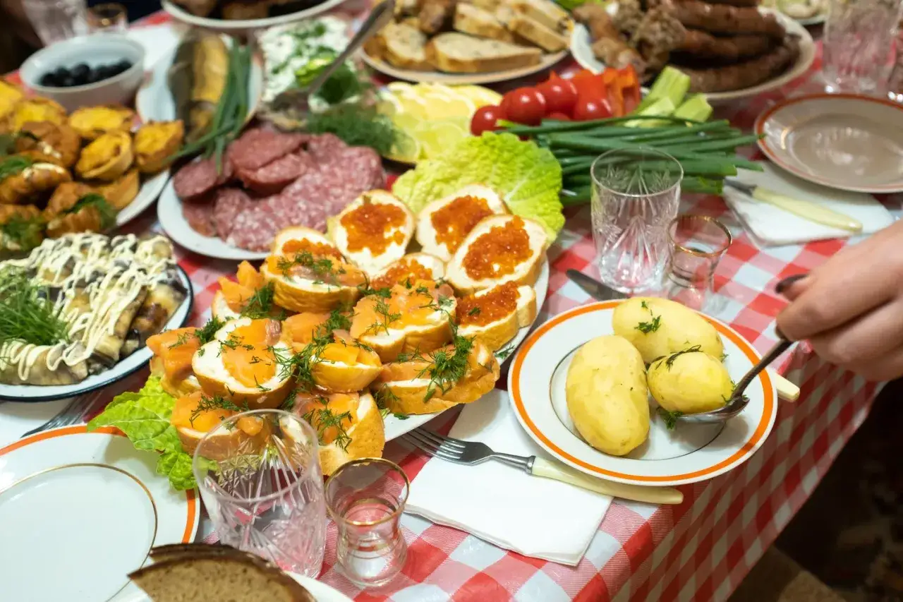 Obficie zastawiony stół z wędlinami, rybami, kawior i ziemniakami to raj dla miłośników turystyki kulinarnej.